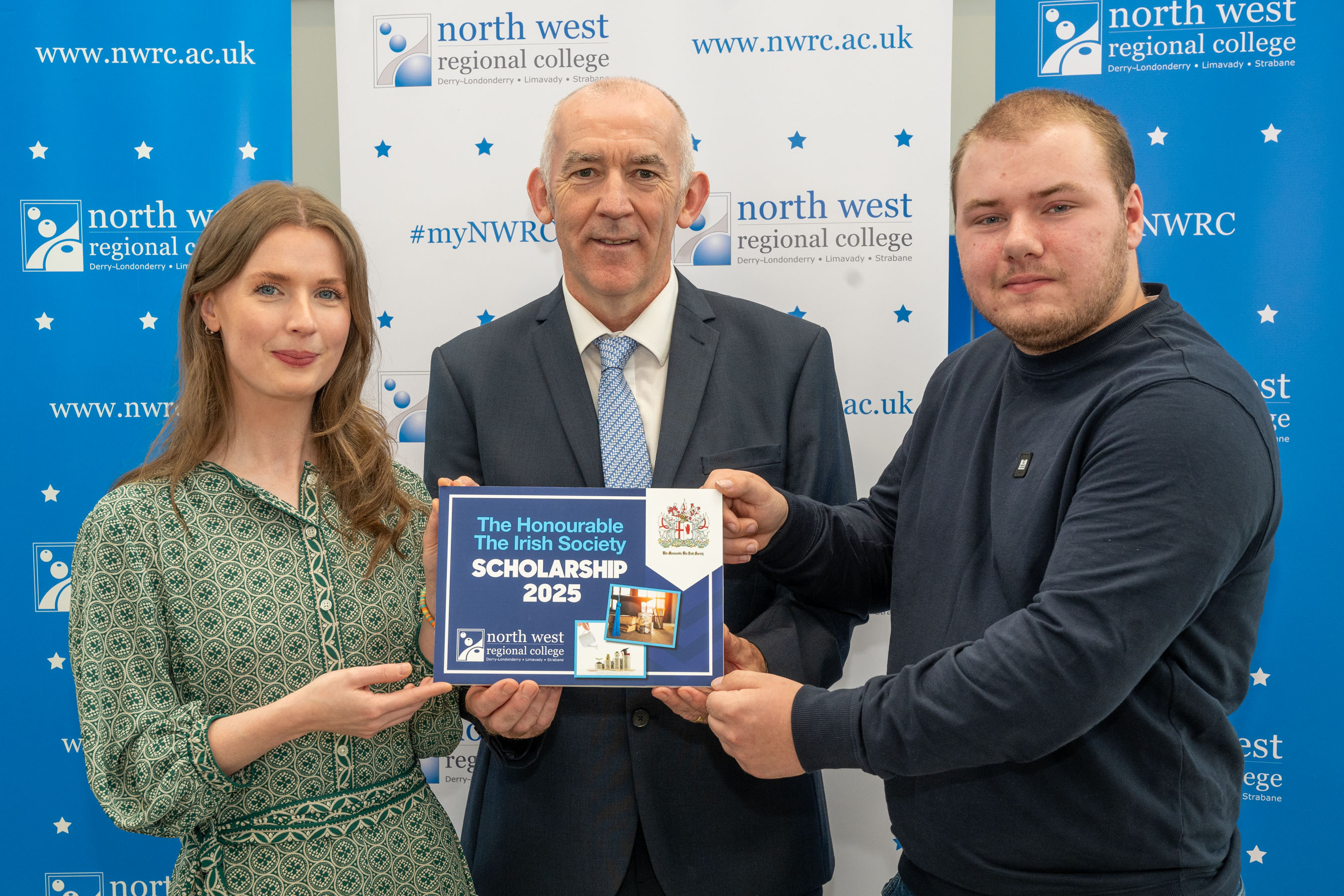 Two men and a woman hold up an awards for the Honourable the irish scholarships.