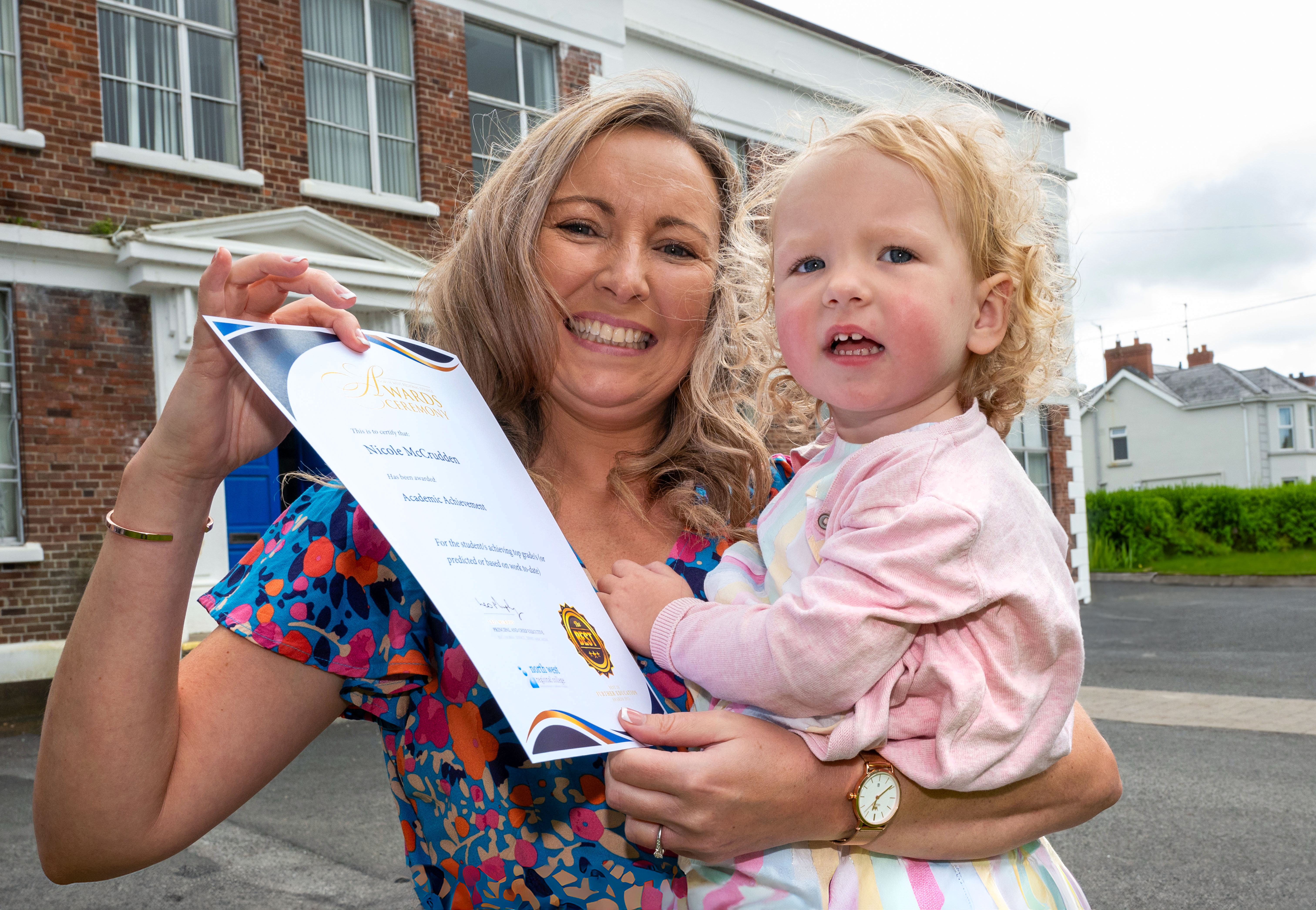 Mum and daughter at celebration event. Mum is holding a certificate
