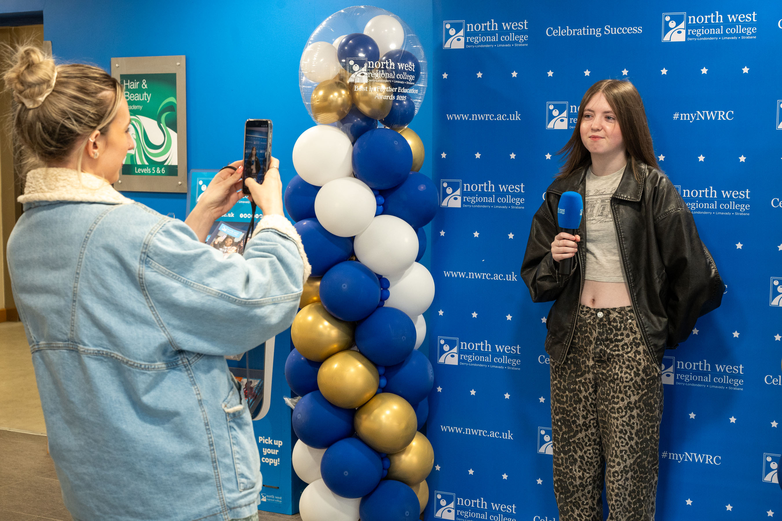 Student holding a mic while being interviewed