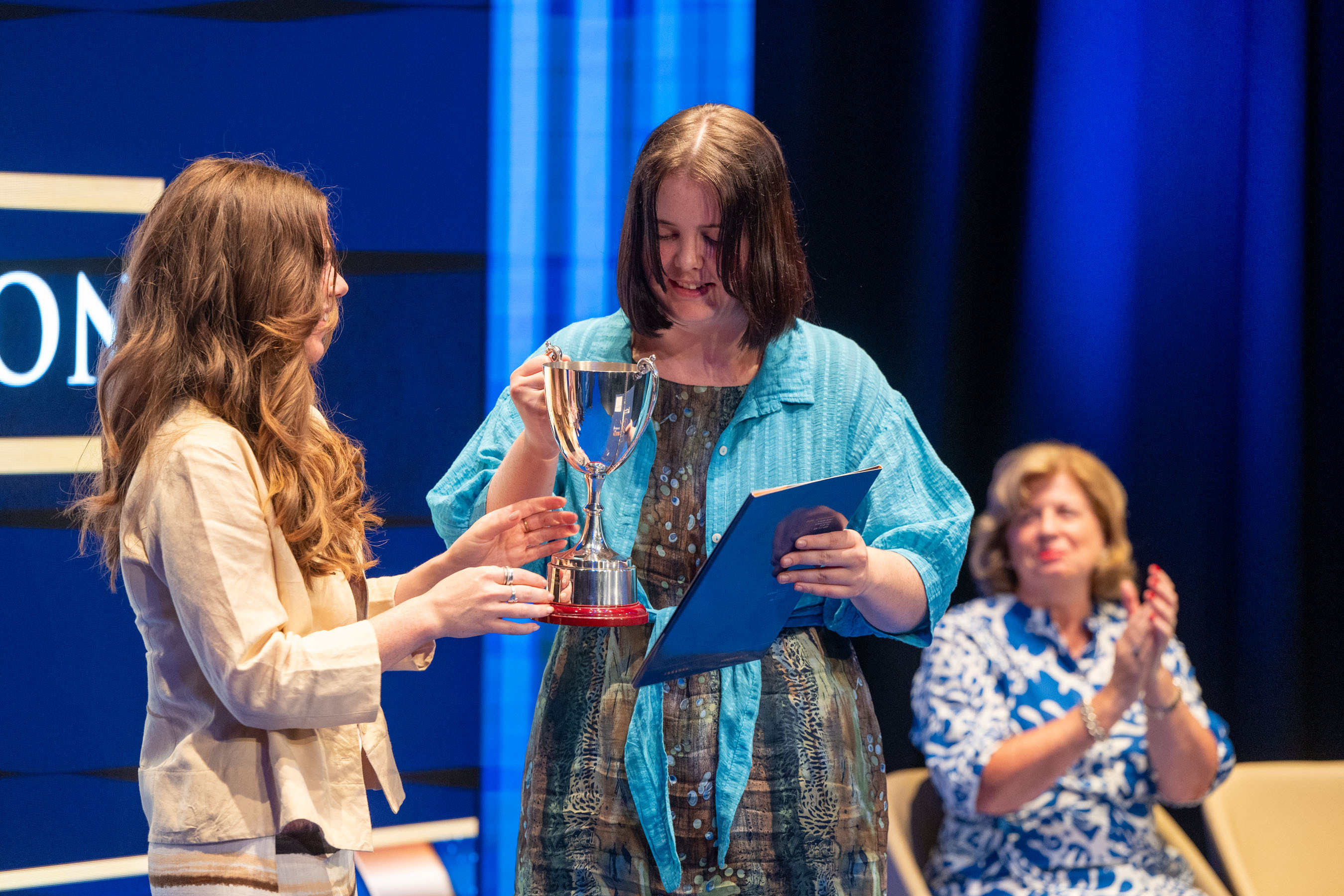 Student receives trophy on stage