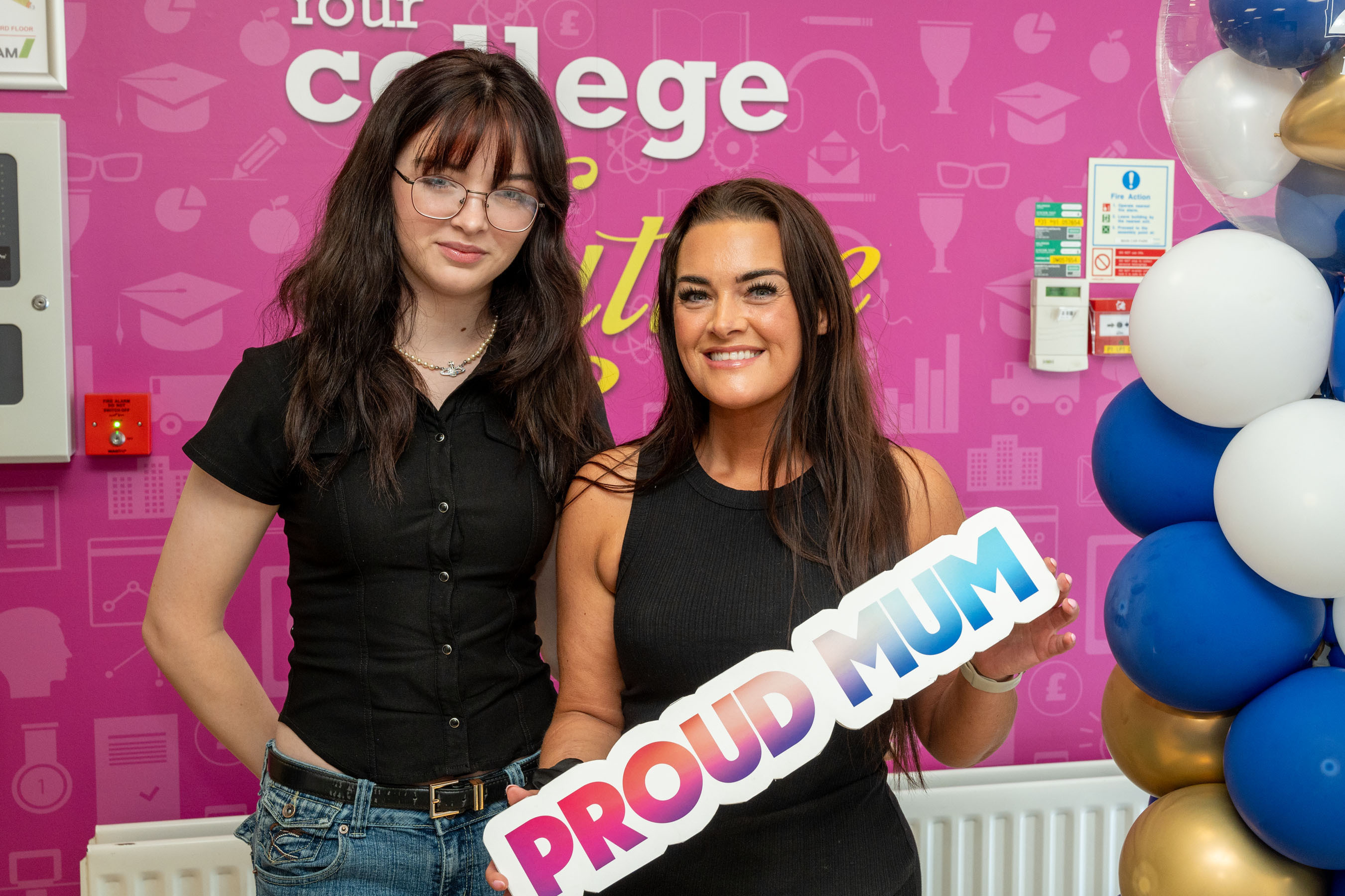 Five people at celebration event. One is holding a certificate, one has a proud mum sign.
