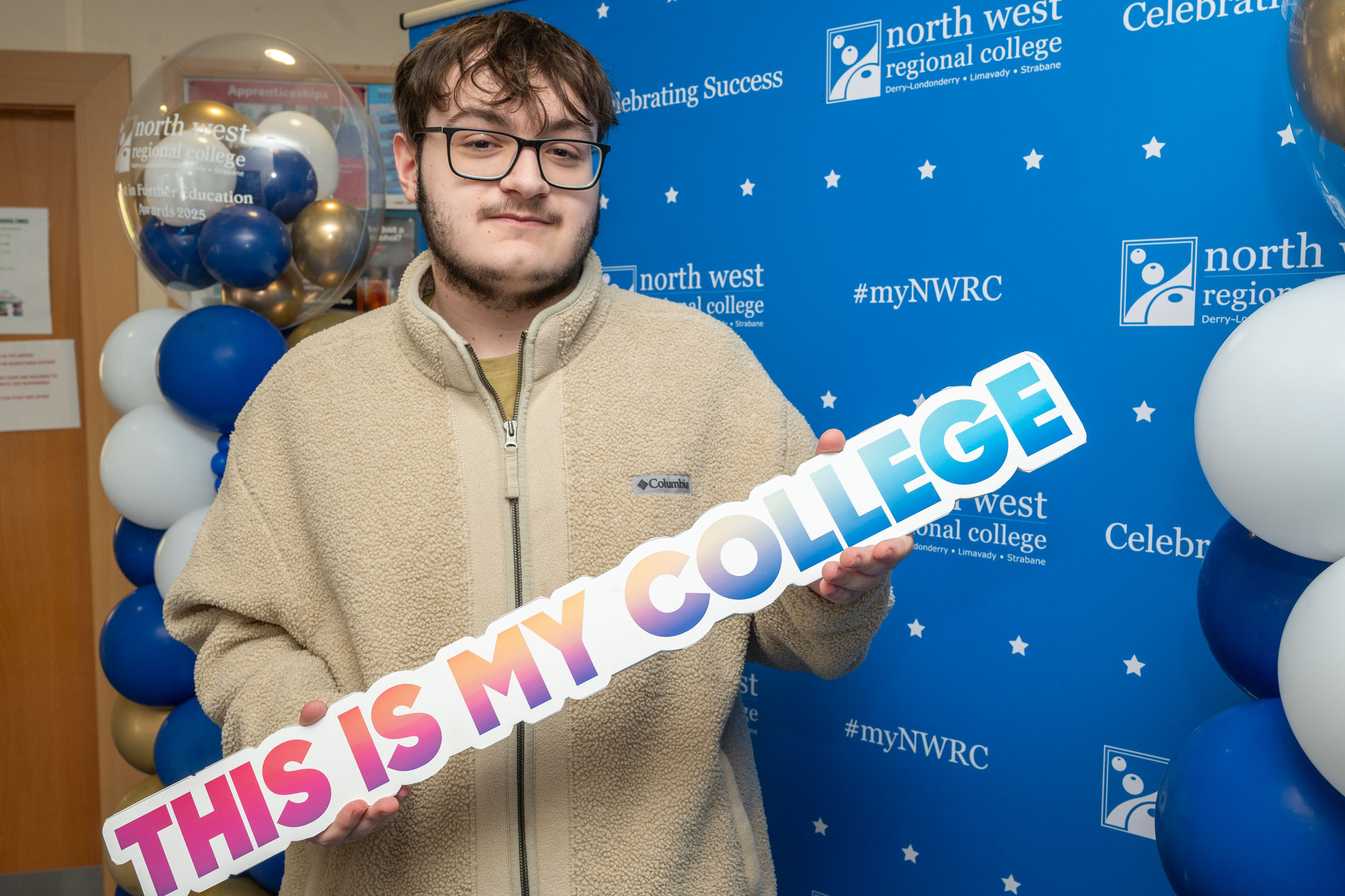 Student holding a sign that says This is my college