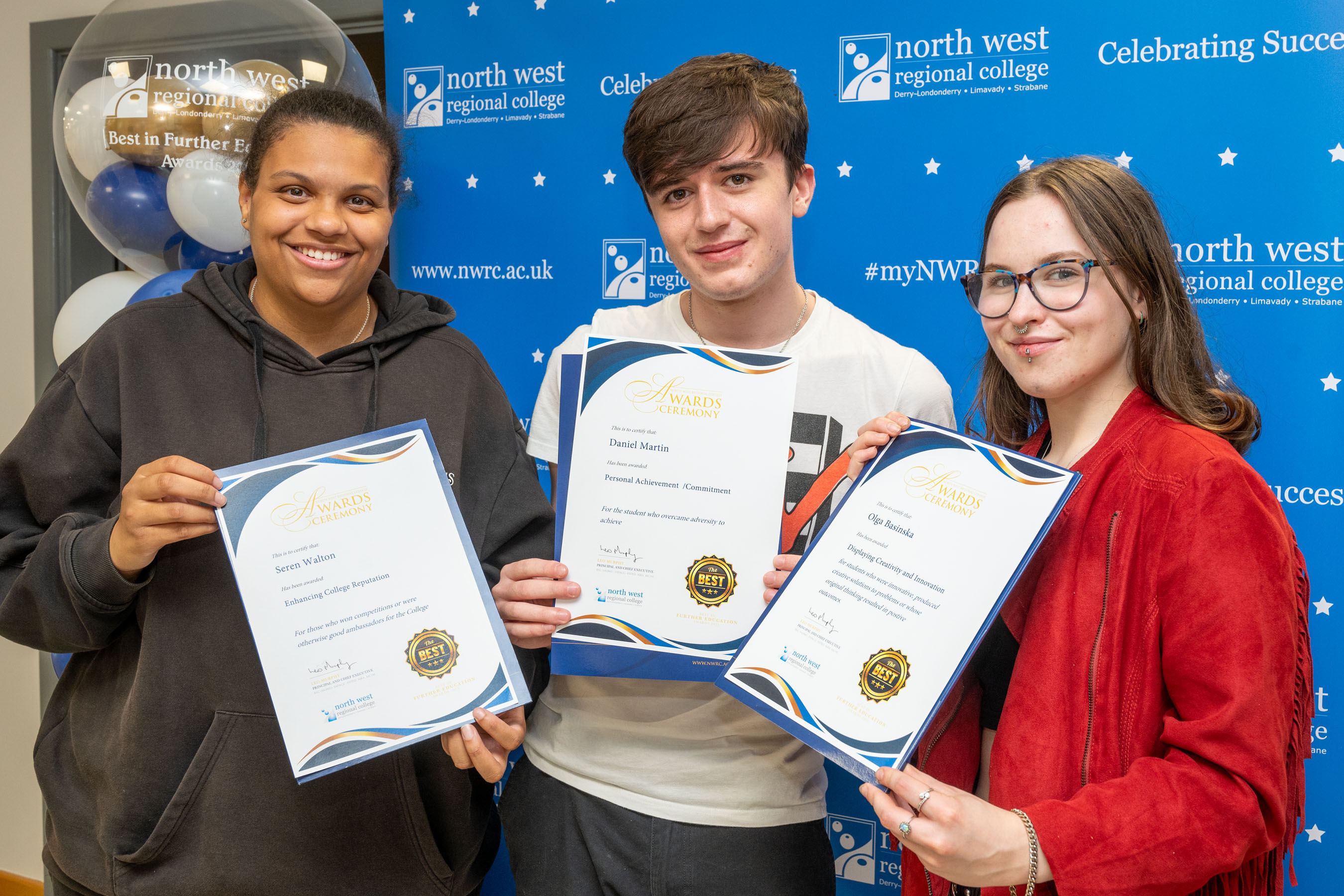 Three students show off their certificates