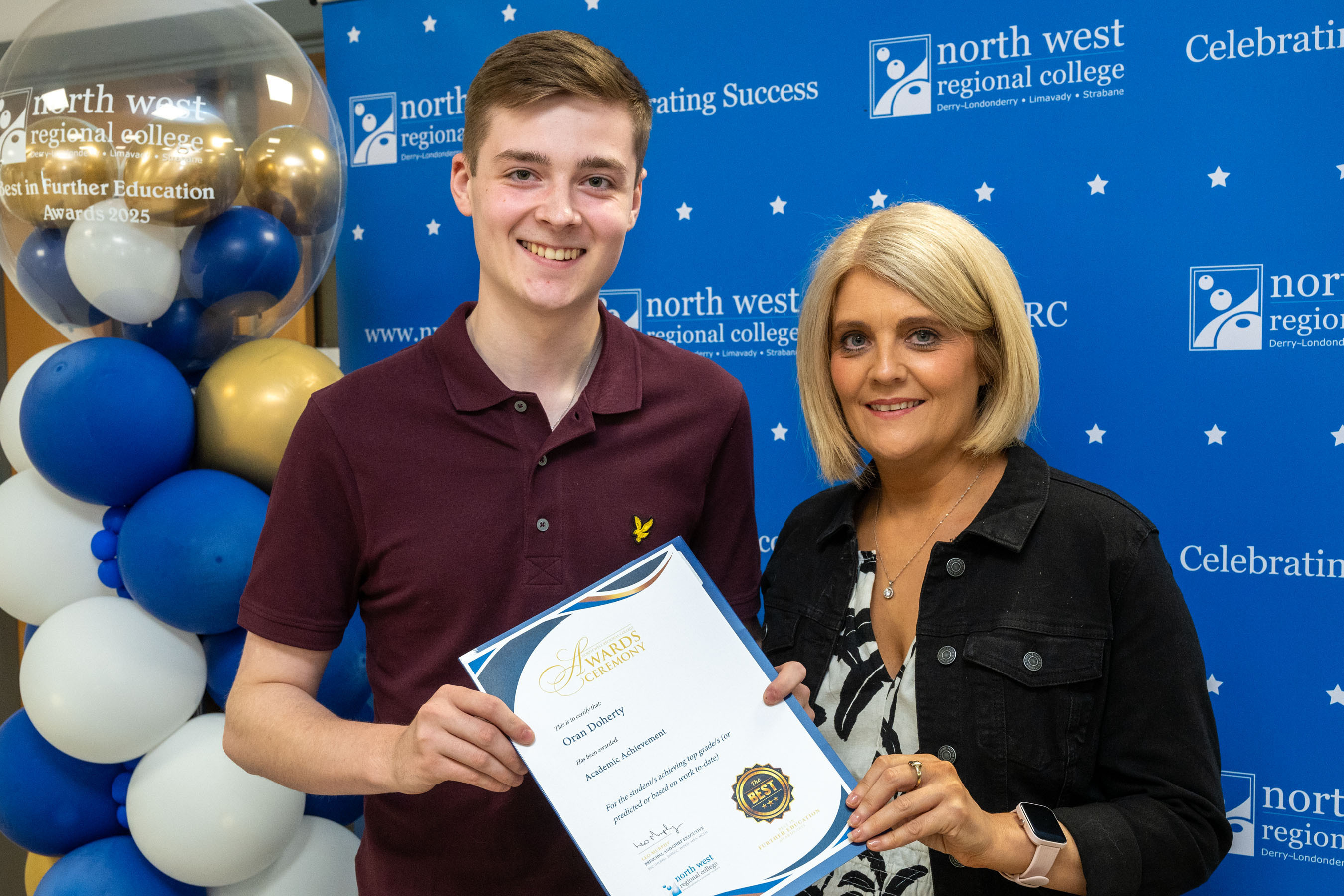 Two people at celebration event. One is holding a certificate