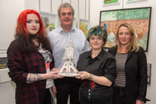 two young female students with their lecturers holding an award