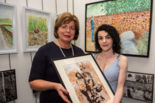 Two women hold the award