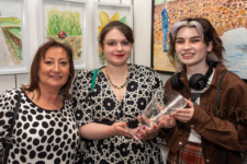 Two students and lecturer holding award