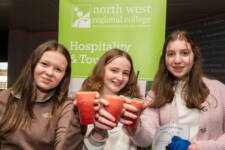 Three students holding up drinks