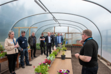 Group of people standing in Horticulture greenhouse surrounded by plants