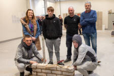 A group of 6 people being shown brickwork