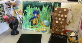 Art & Design student's desk with paintings and sculptures