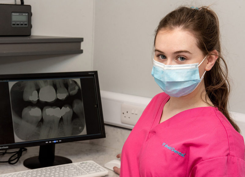 Female Dental Nursing apprentice Niamh Mc Henry pictured in the Braid Dental surgery standing in front of screen showing a patients teeth x ray