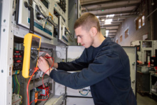 Electrical engineering apprentice working on the job