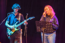 Male guitarist and female singer perform on stage at College Open Day