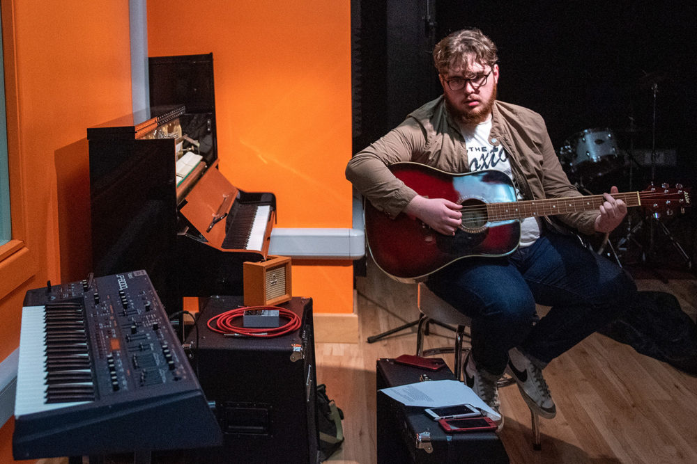 Joe practices playing guitar in the NWRC Recording Studio