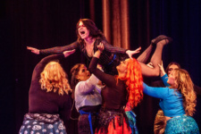 Performing Arts students hold female classmate above their heads during a show in the College's Foyle Theatre