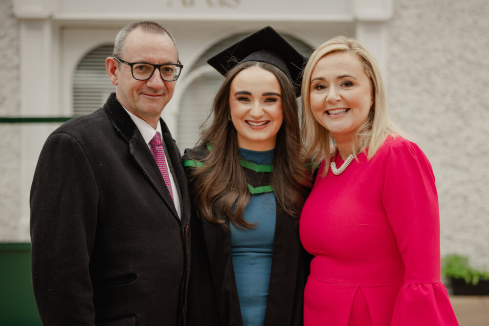 Female graduate smiling with her parents