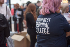 Lady with pink hair wearing tshirt with writing on the back