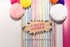 Arrow sign with 'Circus Games' and paper balloons