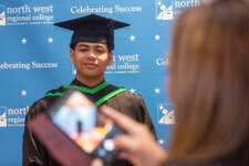 Middle Eastern male graduate poses for a photo