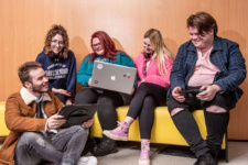Mixed group of students sit together on yellow sofa in the NWRC Student Zone