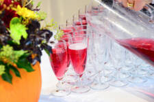 Staff pouring red juice into champagne glasses