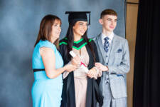 Female graduate poses with mother and brother for offical photography