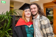 Female graduate smiles with her boyfriend during Graduation ceremony