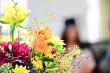 Flowers in foreground with blurred graduate in the background