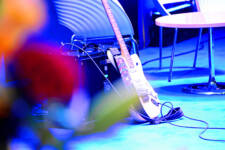 Guitar pictured on stage at graduation ceremony with flowers in foreground