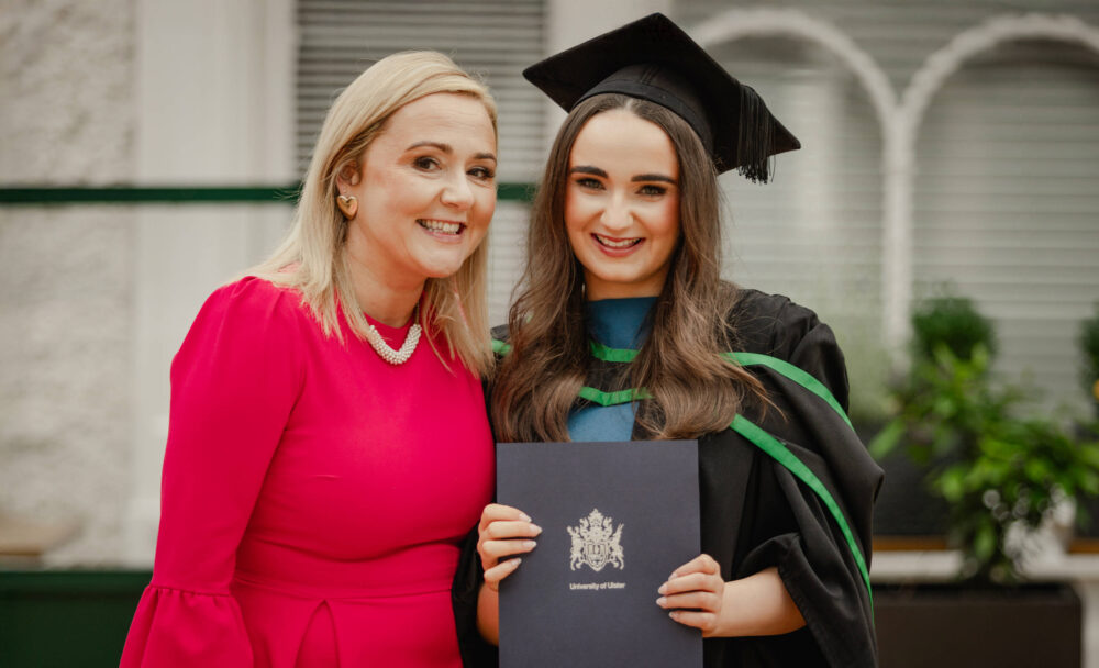 Female graduate holding university degree with her mother