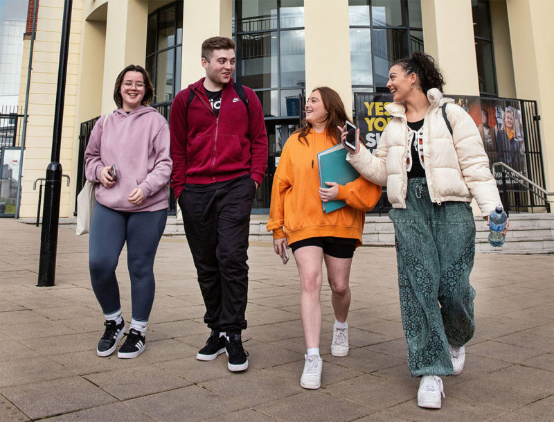 Group of friends walking outside Strand Road campus