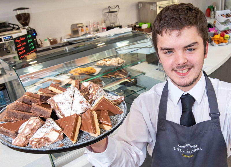 Hospitality student Ben Hall servies up brownies and caramel squares NWR Cs new Barista at Strand Road campus