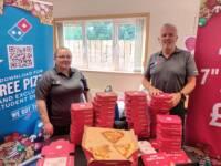 Staff handing out free pizza at an event