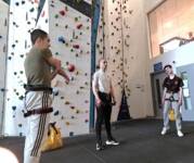 three males at a climbing wall