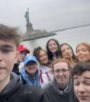 group of young people in front of The Statue of Liberty