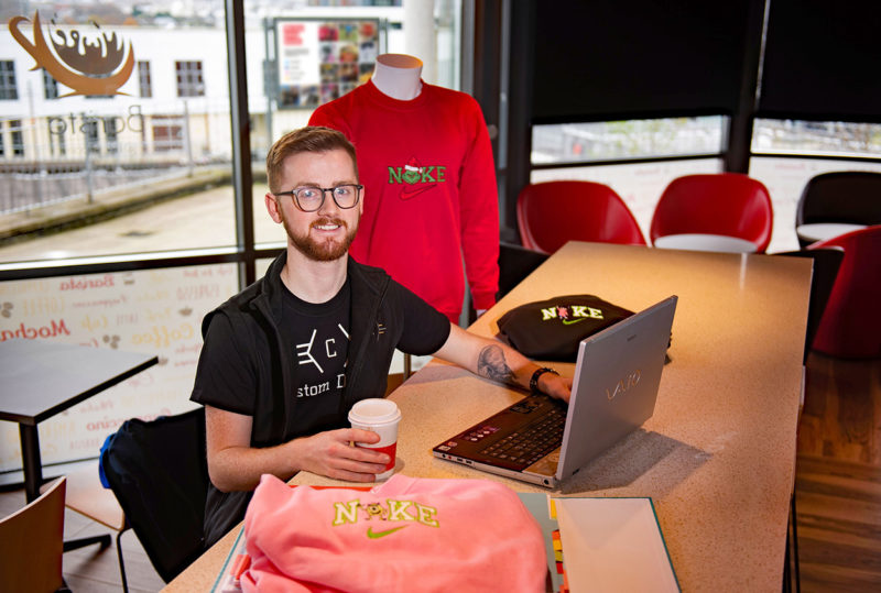 Male business student sitting at a laptop in college cafe web