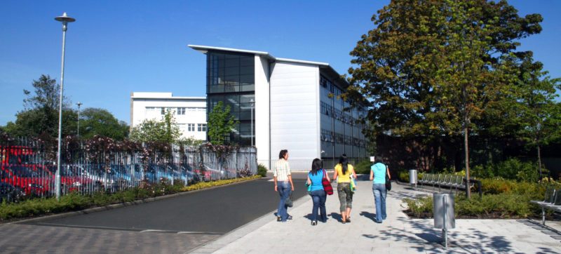 4 female students walk towards their college campus