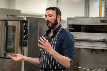 Chef gives a talk in an industrial kitchen