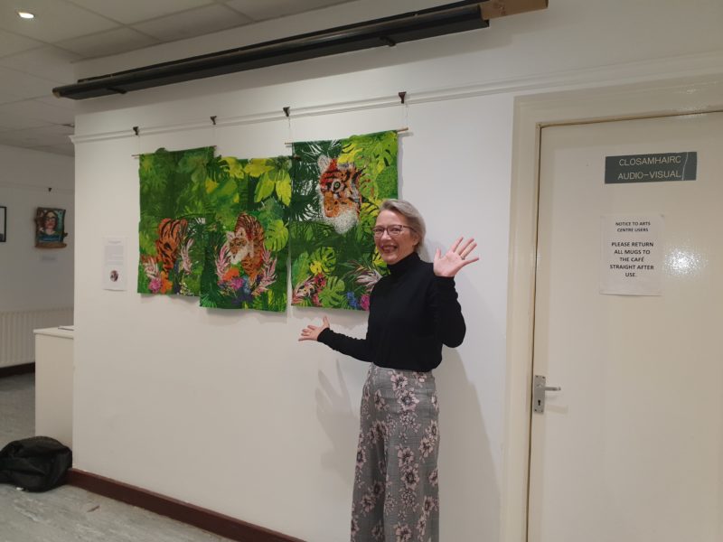 woman with jazz hands standing in front of a painting