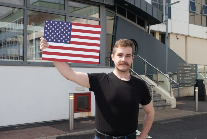 Male student holding an american flag