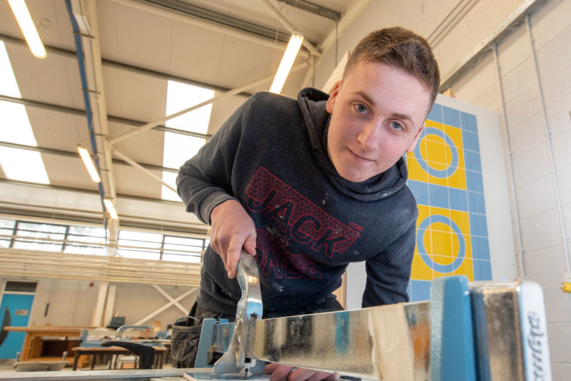 Student using tools in tiling workshop