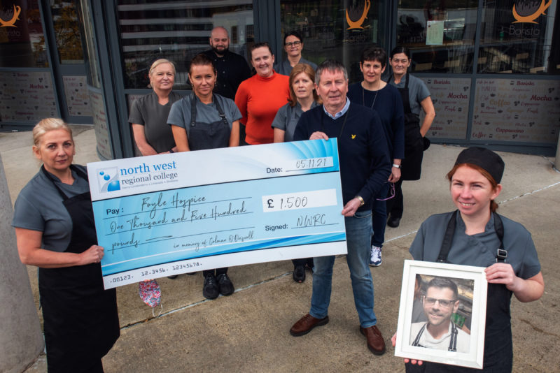 NWRC staff handing large cheque to Foyle Hospice, one staff member is holding a picture of Colman O'Driscoll