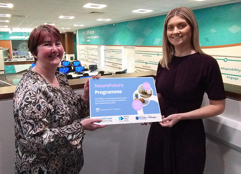 Two ladies in a college environment hold a sign advertising a Neuro Future Programme