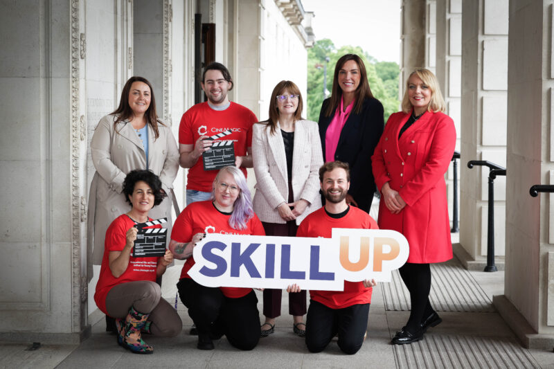 Group of people in an official building holding a graphic that says Skill Up