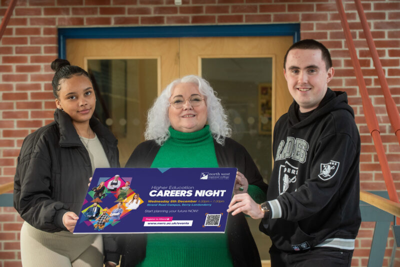 2 students and a lecturer hold up a sign promoting the Higher Education evening at NWRC