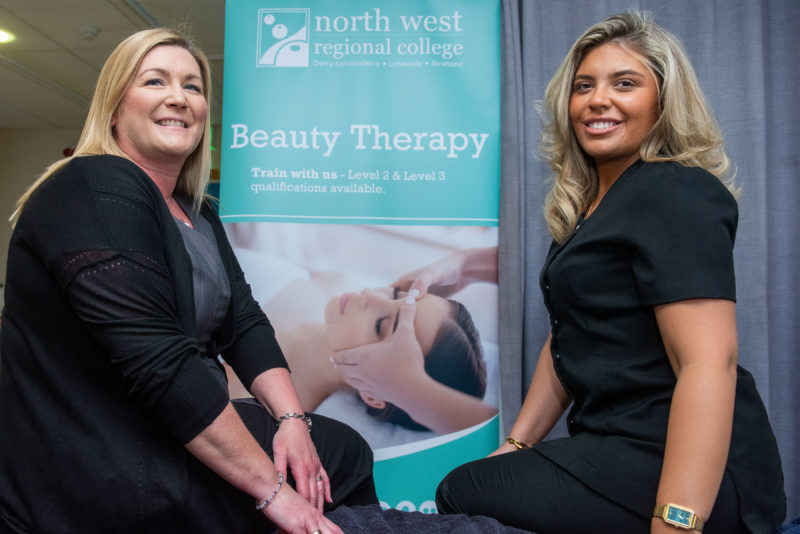 Female lecturer and students in front of a pop up banner for beauty