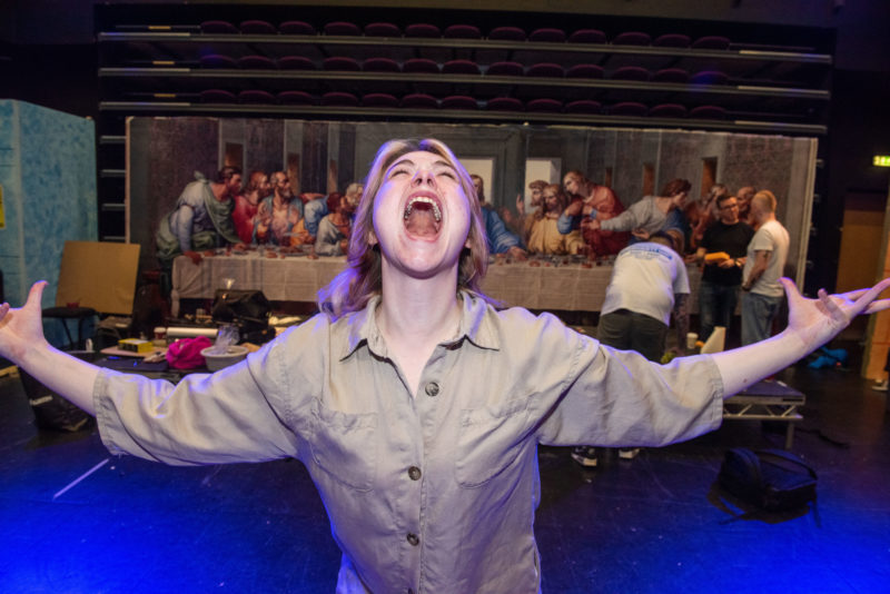 A student in the theatre in a screaming pose