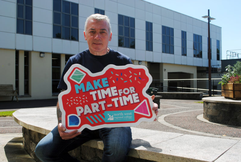 Man holding a sign for part time courses