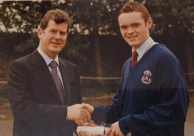 Man and schoolboy shake hands